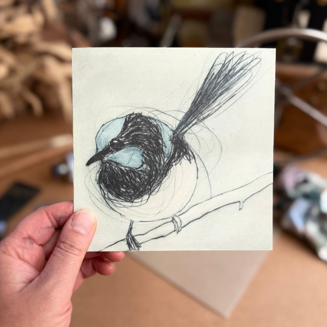 Hand holding a greeting card depicting a superb fairywren