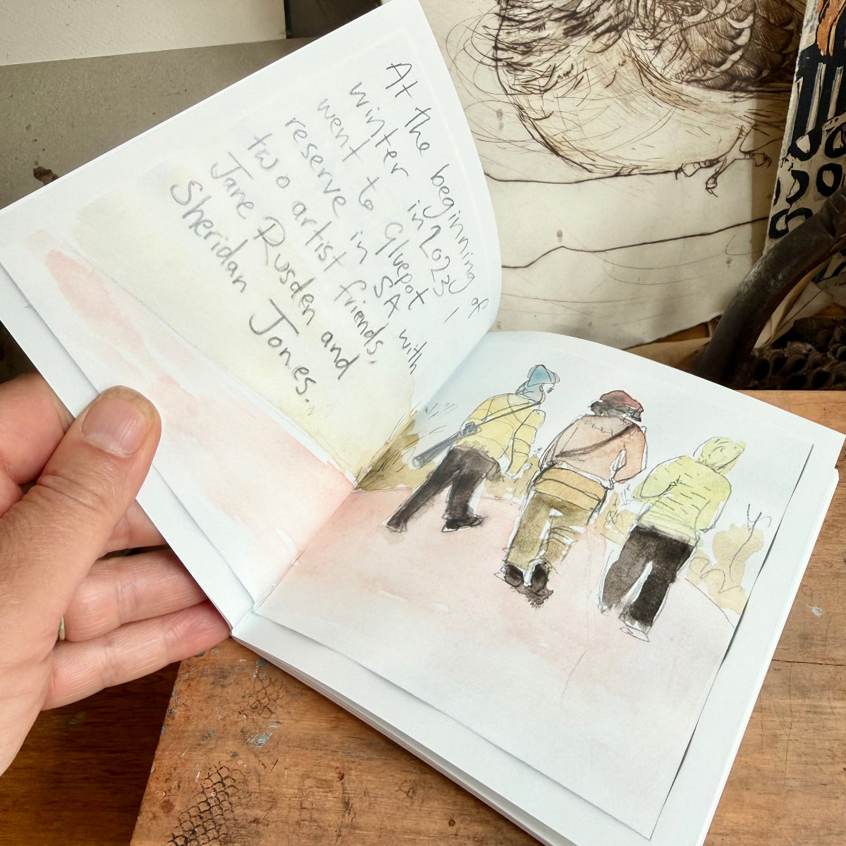 Open book with illustrations and text on a wooden surface