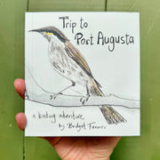 Book titled 'Trip to Port Augusta' with a bird illustration on a green background