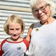 grandmother and her grandson standing together wearing matching enamel birder pins.