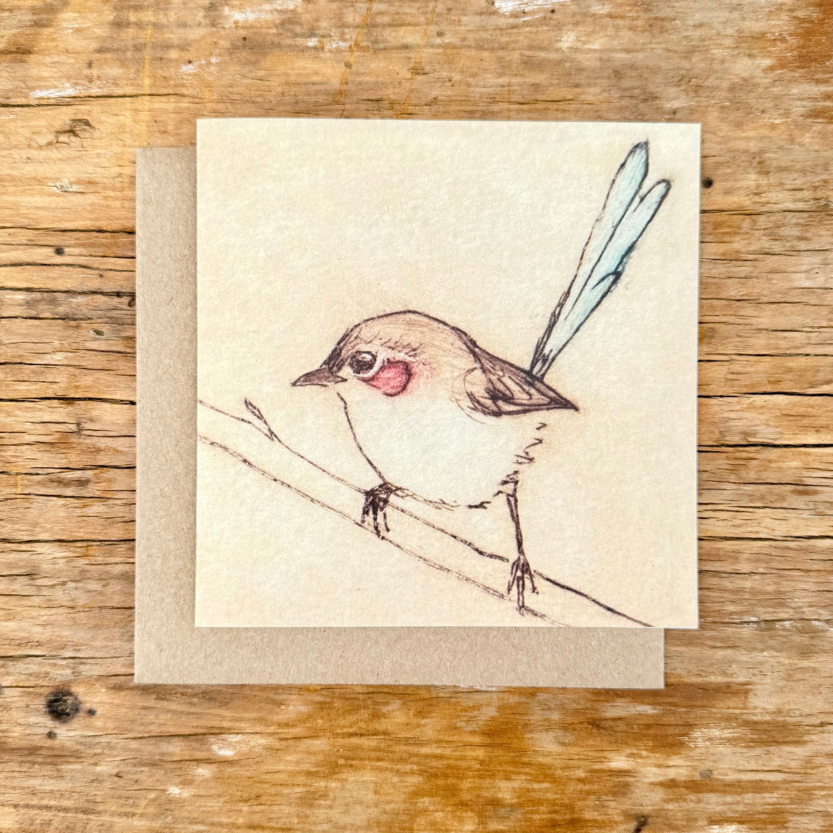 Card with a bird illustration on a wooden surface