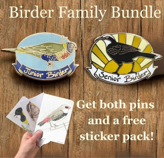 Two bird-themed pins labeled 'Junior Birder' and 'Senior Birder' with a hand holding cards on a wooden background.