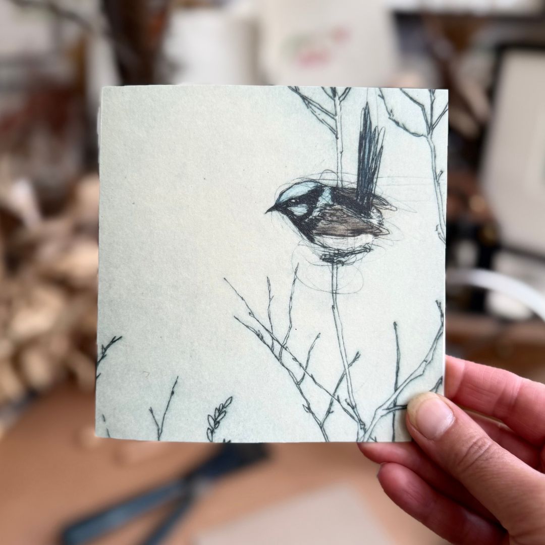 hand holding a greeting card depicting asuperb fairywren