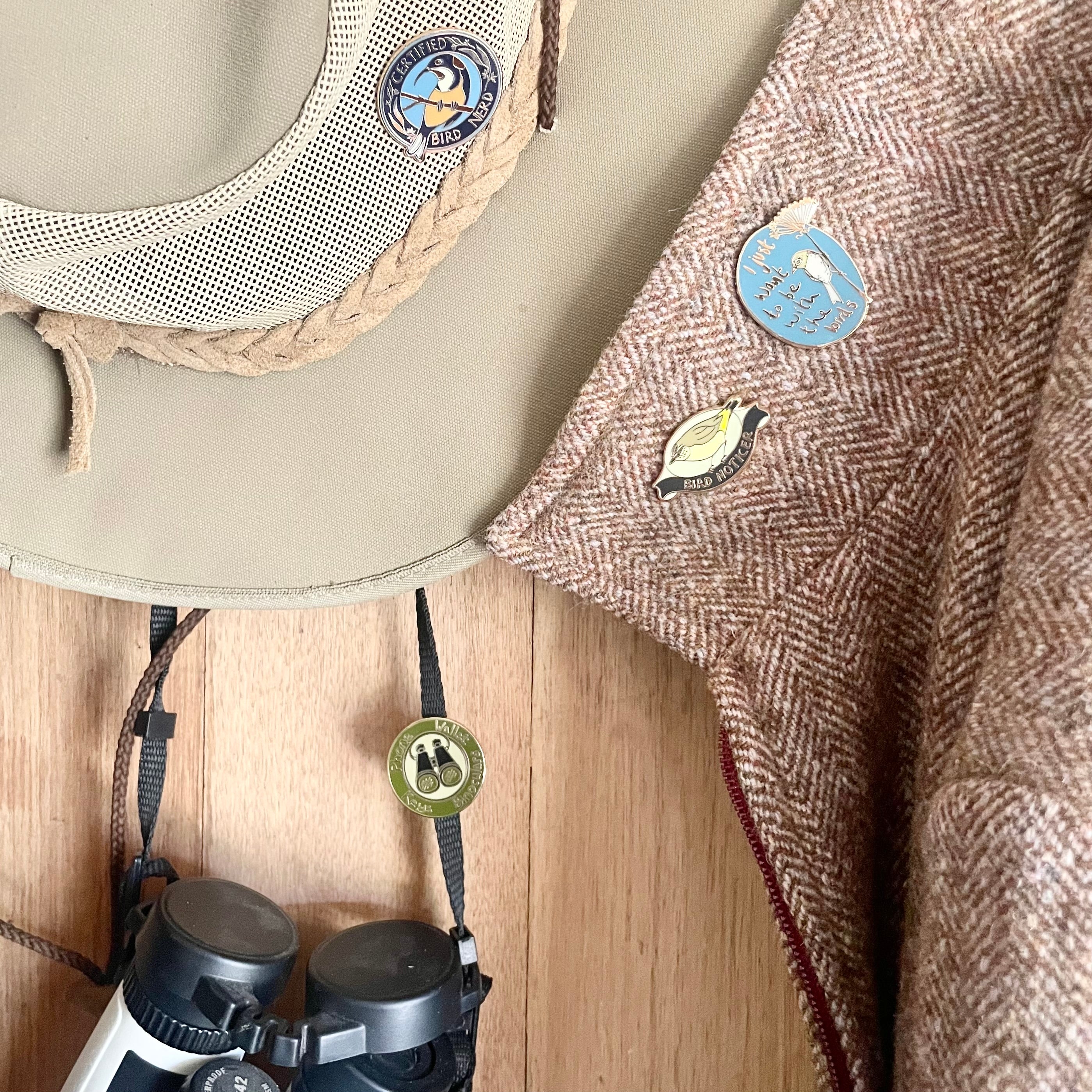 birder pins on hat coat and binoculars